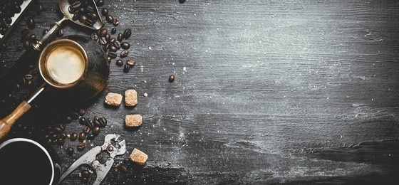 coffee style . brewed coffee pot with sugar and coffee beans around. on a black chalkboard.