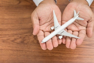 hands support airplane model, insurance tourist concept.