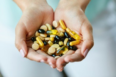 vitamins and supplements. closeup of woman hands holding variety of colorful vitamin pills. close-up handful of medication, medicine tablets, capsules. healthy diet nutrition concept. high resolution