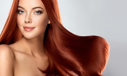 beautiful model girl with shiny red  straight long  hair . care and hair products .