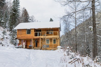 backpacker comes in a wooden house in the woods on the porch