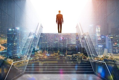 rear view of a businessman climbing stairs to get to a large city center. concept of success and appreciation. toned image. double exposure