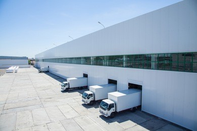 facade of an industrial building and warehouse with freight cars in length