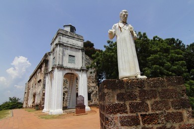 exterior view of st. paul's church in malacca, malaysia with a statue of st. francis xavier in front