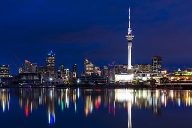 a beautifully still winter's morning in auckland. the city is waking and sky tower  is illuminated.