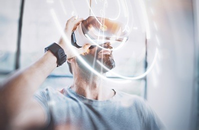 concept of digital screen,connection and interfaces.attractive bearded man enjoyingvirtual reality glasses in modern loft studio.smartphone using with vr goggles headset.flare effect,blurred