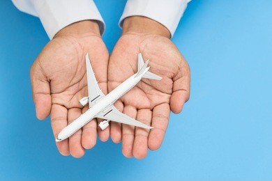 hands support airplane model, travel insurance concept.