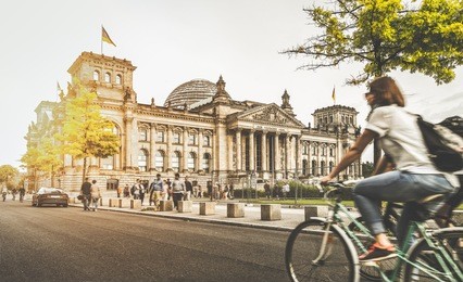berlin urban city life with famous reichstag building in the background in beautiful golden evening light at sunset in summer with retro vintage instagram style pastel toned filter effect, germany
