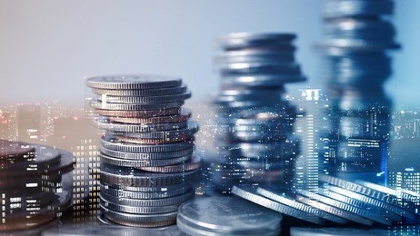 double exposure of city and rows of coins for finance and business concept