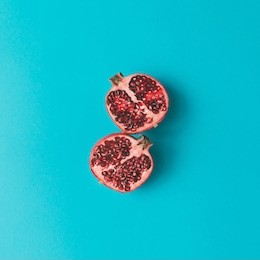 red pomegranate fruit on pastel background. minimal flat lay concept.