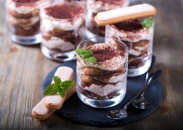 italian dessert tiramisu in glass, sweet food on wooden background