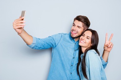 portrait of two happy lovers making selfie on smartphone