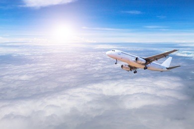 airplane flying away in to sky high altitude above the white clouds