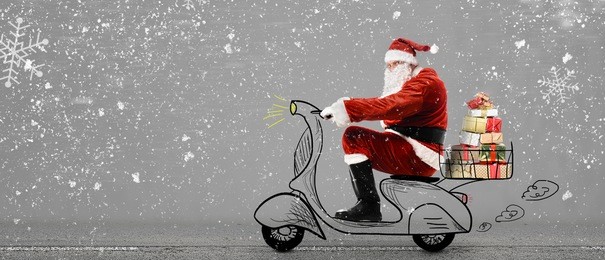 santa claus on scooter delivering christmas or new year gifts at snowy gray background
