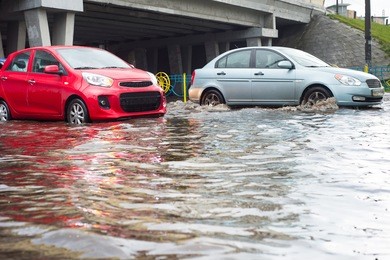 cars on a flooded city road during the rain