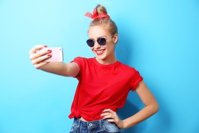 young beautiful woman with smart phone on blue background