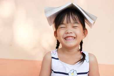 pretty girl the little girl is happy with the book.