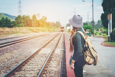 traveler woman walking and waits train on railway platform