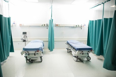 wide view of a couple of empty beds in an emergency room at a hospital