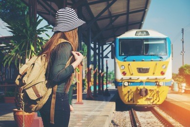traveler woman walking and waits train on railway platform
