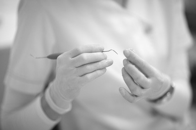 the dentist holds special tools and materials for treating a patient