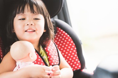 transport, safety, childhood road trip and people concept - happy little girl sitting in baby car seat, child in auto baby seat in car, adorable little girl in the car.
