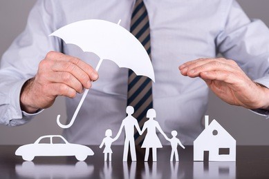 man holding an umbrella protecting a family, a house and a car