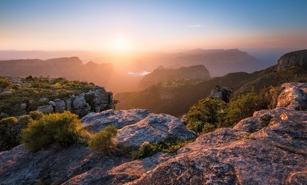 a horizontal photograph of a beautiful sunset over the blyde river canyon taken from mariepskop