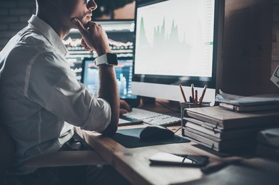 busy working day. close-up of young businessman looking at monitor while sitting at the desk in creative office 
