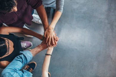 top view image of group of young people putting their hands together. friends with stack of hands showing unity.