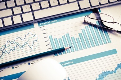 business workplace with keyboard mouse and papers with graphs and diagrams