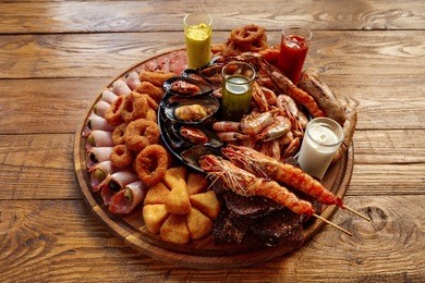 seafood platter. mediterranean cuisine restaurant food, fried calamari rings, king prawns, mussels, oysters, shellfish delicacy on wood table background. catering, banquet table