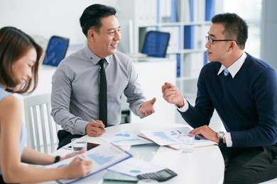 coworkers discussing financial reports at the meeting