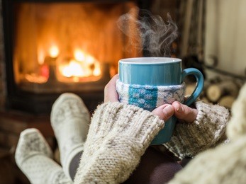 warming and relaxing near fireplace with a cup of hot drink.
