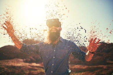 bearded guy in desert wearing vr glasses dissolving into pixels