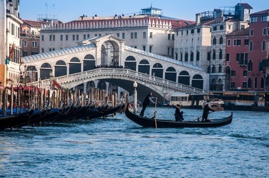 traghetto gondola ferry crossing the gran canal near the rialto bridge, in venice.