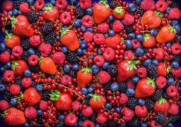 berries overhead closeup colorful assorted mix of strawberry, blueberry, raspberry, blackberry, red currant in studio on dark background