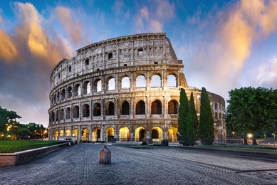 colosseum in rome at sunset with lights, italy