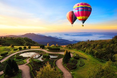 colorful hot-air balloons flying over the doi inthanon national park with sunrise and morning mist at chiang mai, thailand.