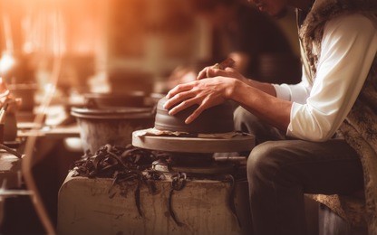 craftsman artist making craft, pottery, sculptor from fresh wet clay on pottery wheel, selected focus