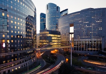 night architecture - skyscrapers with glass facade. modern buildings in paris business district. evening dynamic traffic on a street. concept of economics, financial.  copy space for text. toned