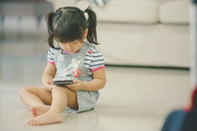 child girl happy look smart phone.child development concept.little asian girl look smart phone in living room.
