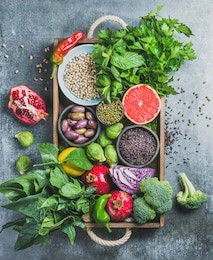 vegetables, fruit, seeds, cereals, beans, spices, superfoods, herbs, condiment in wooden box for vegan, gluten free, allergy-friendly, clean eating or raw diet. grey concrete background and top view