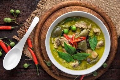 thai food chicken green curry on dark wooden background. top view