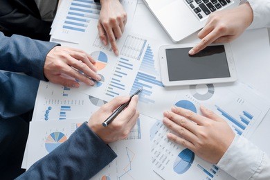 teamwork process, business team hands working analyzing a new start up project with financial documents data plan and a tablet to development, grow to success on office desk,  top view shot.