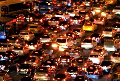 aerial view of modern city skyline street cityscape night time with heavy traffic red stop back lights de-focused abstract blurry design concept design background