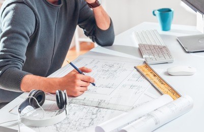 architect working on blueprint. architects workplace - architectural project, blueprints, ruler, laptop and divider compass. construction concept. engineering tools.