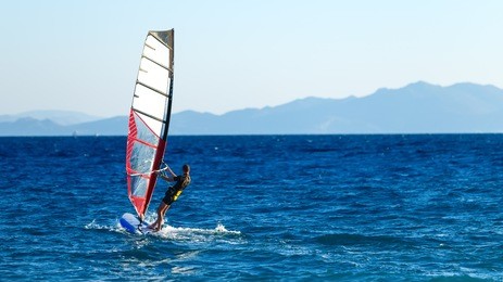 windsurfer in the background of mountains in the distance. summer sunny day. greece, rhodes