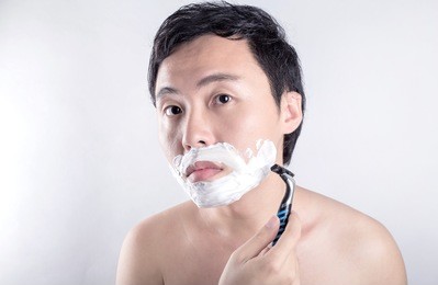 asian man is shaving