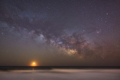 moonrise and milky way rising over the ocean 